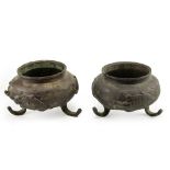 A PAIR OF ORIENTAL BRONZE PLANT STANDS decorated with water dragons each 15cm diameter x 8cm in