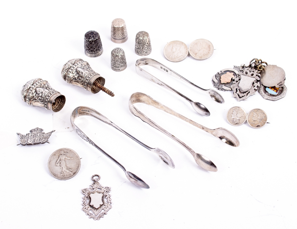 A COLLECTION OF SILVER to include sugar tongs, thimbles, medallions on gilt metal chain, coin