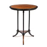 AN EBONISED AMBOYNA WOOD INLAID CIRCULAR OCCASIONAL TABLE with fluted supports and sabre legs 57cm