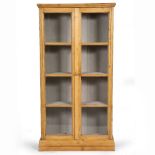 A PINE CABINET with sectional glazed doors 80cm wide x 28.5cm deep x 160cm high