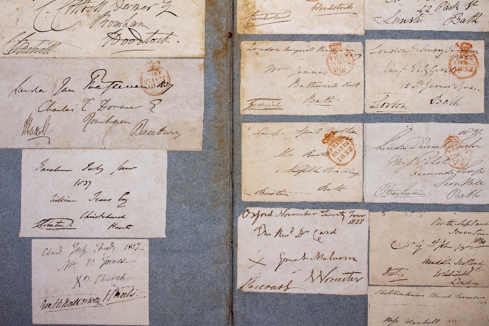 AN ANTIQUE SCRAP BOOK containing fragments of franked envelopes and signatures from The House of