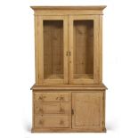 AN EARLY 20TH CENTURY PINE GLAZED DRESSER with fielded panel doors surrounding a glass front, the