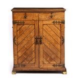 A VICTORIAN OAK GOTHIC REVIVAL CUPBOARD with two drawers and two doors on brass square feet 89.5cm