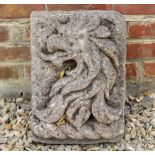 AN ANTIQUE CARVED STONE PLAQUE with a dragons head relief 31cm wide x 41cm in height x 19cm deep