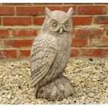 A CAST RECONSTITUTED STONE SCULPTURE of a long eared owl, perched on a rocky out crop 48cm high