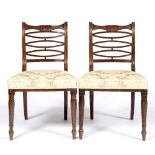 A PAIR OF GEORGE III MAHOGANY DINING CHAIRS with carved shapes and horizontal splats, reeded