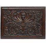A RECTANGULAR RELIEF CARVED OAK PANEL decorated with a central mask surrounded by an Anthemion and