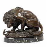 AN ANIMALIER BRONZE SCULPTURE OF A LION fighting a serpent, the sculpture mounted on an oval