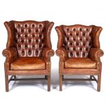 TWO SIMILAR GEORGIAN STYLE LEATHER BUTTON UPHOLSTERED WING BACK ARMCHAIRS on fluted square front