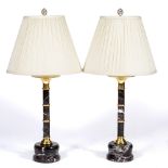 A PAIR OF TURNED MARBLE TABLE LAMPS with brass mounts and pleated silk shades, the base to each lamp