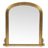 A 19TH CENTURY STYLE GILT OVERMANTLE MIRROR with arching top and scrolling leaf brackets 88cm wide x