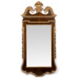 A GEORGE II WALNUT AND CARVED GILT WOOD WALL MIRROR or pier glass, the swan neck pediment with