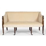 A REGENCY MAHOGANY SOFA with turned arm supports and conforming ring turned front legs terminating