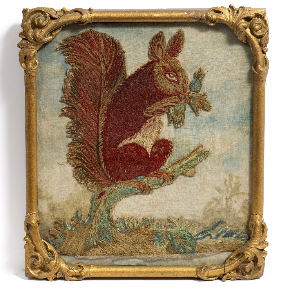 A 19TH CENTURY NEEDLEWORK TAPESTRY PANEL of a red squirrel perched on a branch, holding a nut 23.5cm