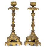 A PAIR OF GILT METAL KNOPPED CANDLESTICKS on triform bases, decorated with Rococo style scrolls