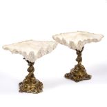 A PAIR OF CONTINENTAL SHELL MOUNTED BON BON DISHES with entwined dolphin supports to the cast