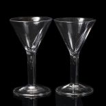 A PAIR OF ANTIQUE WINE GLASSES with conical bowls, air bubble inclusion in the stem and spreading