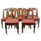 A SET OF EIGHT VICTORIAN OAK DINING CHAIRS with a single pierced splat, upholstered seats, turned