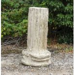 A CAST RECONSTITUTED STONE FLUTED COLUMN BASE after the antique, approximately 52cm diameter x