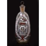 A BOHEMIAN GLASS DECANTER painted in white, red and blue with blacksmith's tools within a wreath and