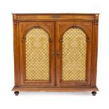 A CONTINENTAL WALNUT SIDE CABINET the twin arching doors with gilt metal lattice inserts opening