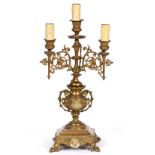 A VICTORIAN CAST BRASS THREE LIGHT, TWO BRANCH CANDELABRUM with Gothic style decoration, central urn