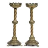 A PAIR OF GOTHIC STYLE BRASS CANDLESTICKS with pierced sconces, twisting knopped stems and