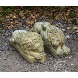 A PAIR OF CAST RECONSTITUTED STONE RESTING LIONS after the antique, each approximately 47cm long (