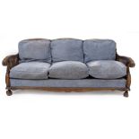 AN EARLY 20TH CENTURY CANED BERGERE THREE SEATER SETTEE with scrolling arms, 186cm wide x 85cm