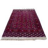 A RED GROUND BALUCHI RUG the central field set with medallions within a banded border, 282cm x 186cm
