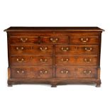 A GEORGE III OAK MULE CHEST the lifting lid over five faux drawers and four further drawers, flanked