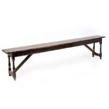 AN ANTIQUE AND LATER OAK LONG BENCH with turned jointed supports, 244cm long x 27cm deep x 55cm