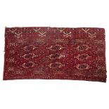A LATE 19TH / EARLY 20TH CENTURY TEKKE TURKMEN RED GROUND RUG with three rows of guls, 133cm x 71cm