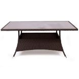 A WOVEN COMPOSITE RATTAN EFFECT GARDEN TABLE with a glass inset top, 161cm wide x 90cm deep x 73cm