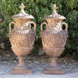 A PAIR OF CAST TERRACOTTA GARDEN URNS AND COVERS with pineapple finials,