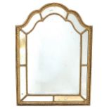 A 19TH CENTURY GILDED GESSO FRAMED WALL MIRROR with beaded decoration, shaped arching top and a