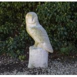 A RECONSTITUTED STONE SCULPTURE of a barn owl, standing on a perch, 78cm high