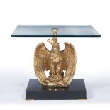 AN EMPIRE STYLE GLASS TOPPED LOW OCCASIONAL TABLE with gilt eagle support and ebonised platform