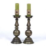 A PAIR OF TURNED BRASS PRICKET CANDLESTICKS on spreading bases, 22cm diameter x 52cm high (2)