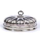 AN ANTIQUE SILVER PLATED FOOD COVER of oval form with lobed body and decorative engraved crests to