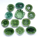 A GROUP OF TWELVE 19TH CENTURY GREEN GLAZED POTTERY SMALL LEAF MOULDED DISHES the largest 15cm