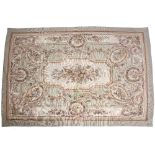 A PALE GREEN GROUND AUBUSSON STYLE NEEDLEWORK CARPET decorated with rose swags, 262cm x 173cm