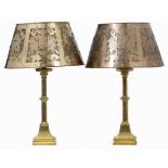 A PAIR OF BRASS TABLE LAMPS with hexagonal knoped stems and rectangular spreading bases, and with