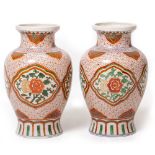 A PAIR OF ORIENTAL PORCELAIN VASES of baluster form, each with green and red foliate decoration,