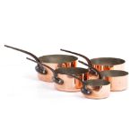 A GRADUATED SET OF FIVE COPPER SAUCEPANS with wrought iron handles, the largest 20cm diameter x 9.