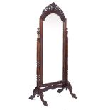 A WALNUT CHEVAL MIRROR the arching bevelled mirror plate within a frame with pierced scrolling