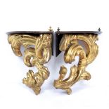 A PAIR OF GILT CARVED WOOD CORNER BRACKETS with scroll decorated supports, 35cm wide x 34cm high (