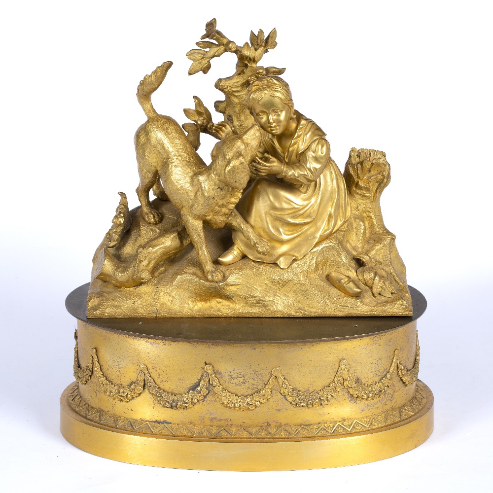 A GILT ORMOLU SCULPTURE of a young girl, with her attentive dog, 24cm wide x 21cm high together with