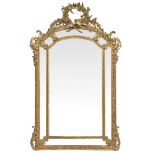 A 19TH CENTURY FRENCH PIER GLASS OR WALL MIRROR with gilt gesso moulded frame, the arching top