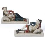 A PAIR OF ANTIQUE CARVED ALABASTER PAINTED FIGURINES depicting a shepherd and shepherdess reclining,